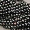 Close-up of Black Tourmaline beads showing natural rust, gray, and brown matrix