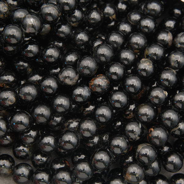 Black Tourmaline round beads with a glossy polished finish and natural mineral inclusions