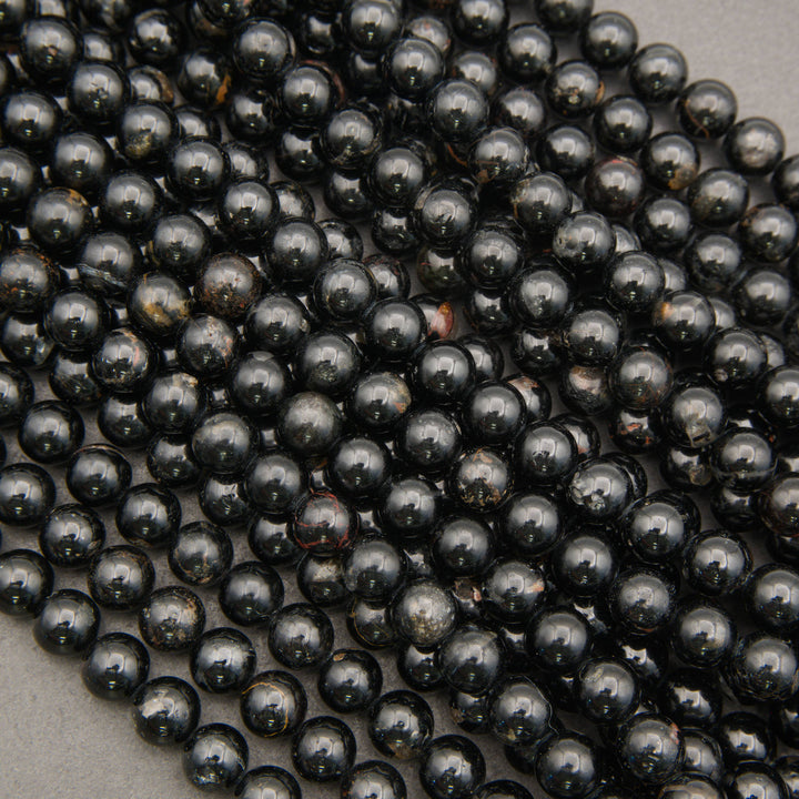 Polished Black Tourmaline gemstone beads with deep black color and earthy brown accents