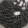 Strands of polished Black Tourmaline beads with occasional mineral inclusions