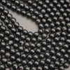 Natural Black Tourmaline gemstone beads featuring deep black tones and scattered earthy markings