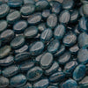 Close-up of glossy smooth oval blue apatite beads in deep teal to dark ocean blue with fine natural fracture lines