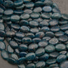 Strands of smooth oval blue apatite beads in dark teal with natural fracture lines