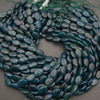 A heap of smooth oval blue apatite bead strands in deep teal
