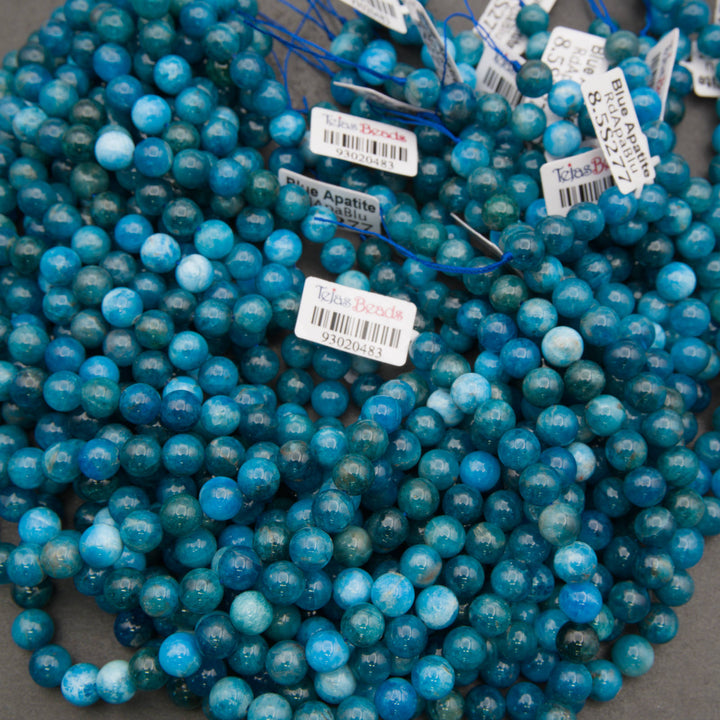 Strands of smooth round blue apatite beads with Tejas Beads tags