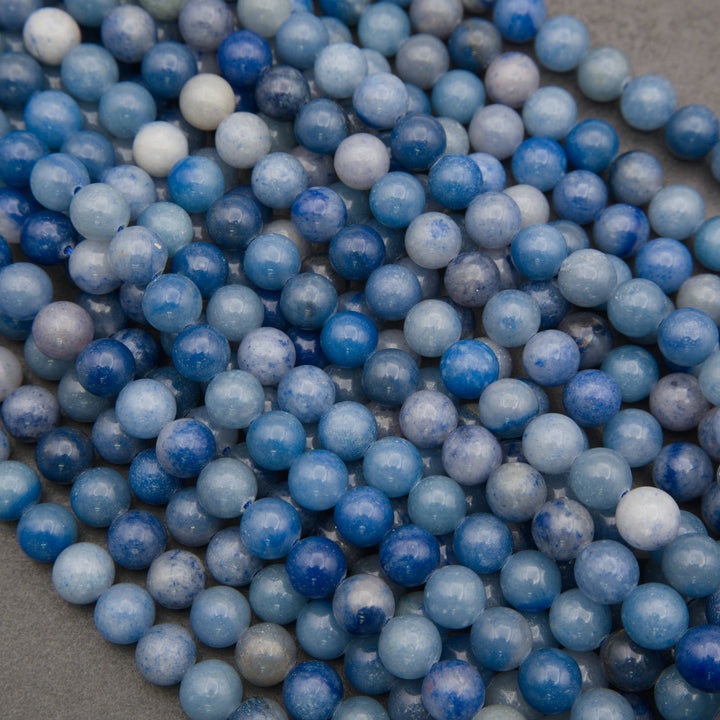 A heap of smooth round blue aventurine bead strands in denim blue, cobalt and soft gray