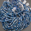 A bundle of smooth round blue aventurine bead strands with Tejas Beads tags