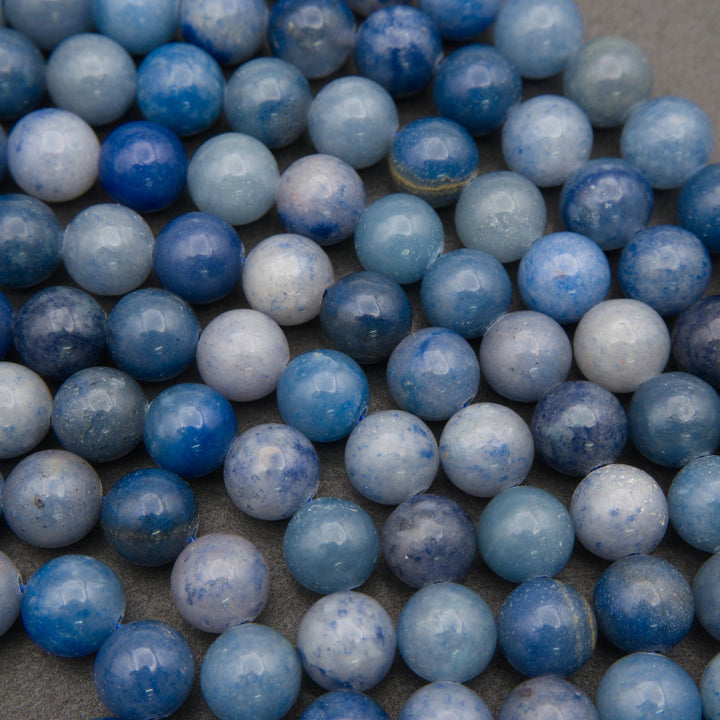 Close-up of polished blue aventurine beads showing cobalt blue with white and gray veins