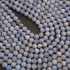 Close-up of blue and white marbled beads on a dark background