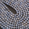 Close-up of blue and white marbled beads on a dark background