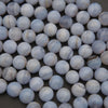 Close-up of blue and white marbled beads on a dark surface