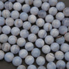 Close-up of blue and white marbled beads on a dark surface
