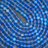Close-up of blue cat's eye beads on a dark background