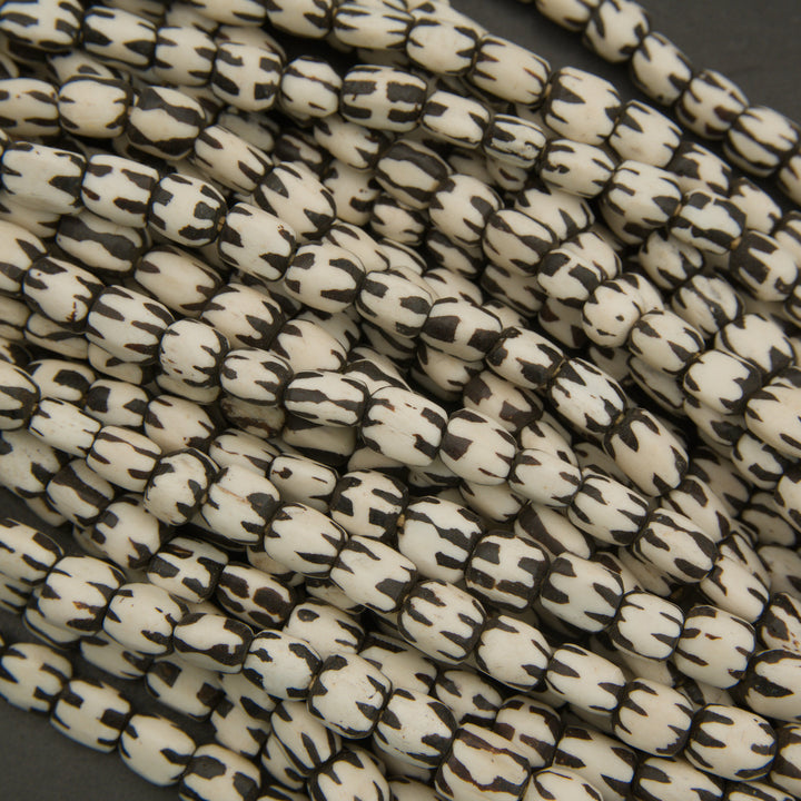 Close-up of white beads with black patterns on a dark background