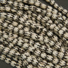 Close-up of white beads with black patterns on a dark background