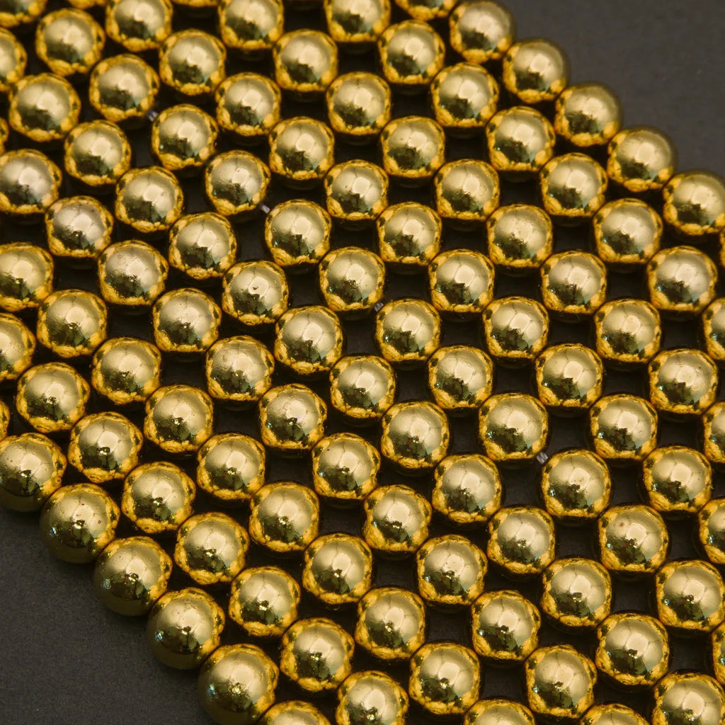 Close-up of gold beads arranged in a grid pattern on a dark background