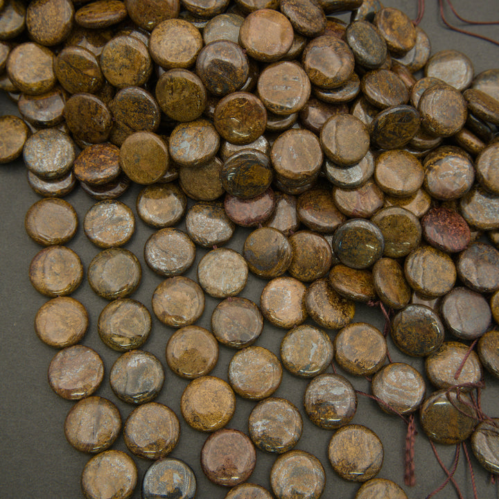 Collection of round, brownish coins on a dark surface