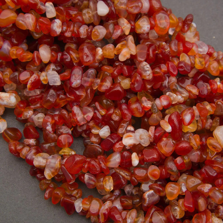Close-up of a string of red and orange gemstones on a gray background