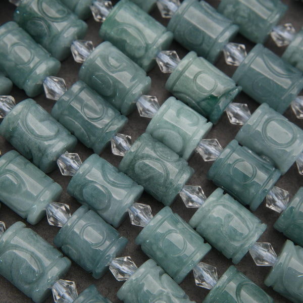 Teal cylindrical beads with clear crystal-like accents on a dark background