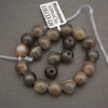 String of brown beads with a label on a gray background