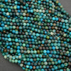 Close-up of blue and green beads on a dark surface
