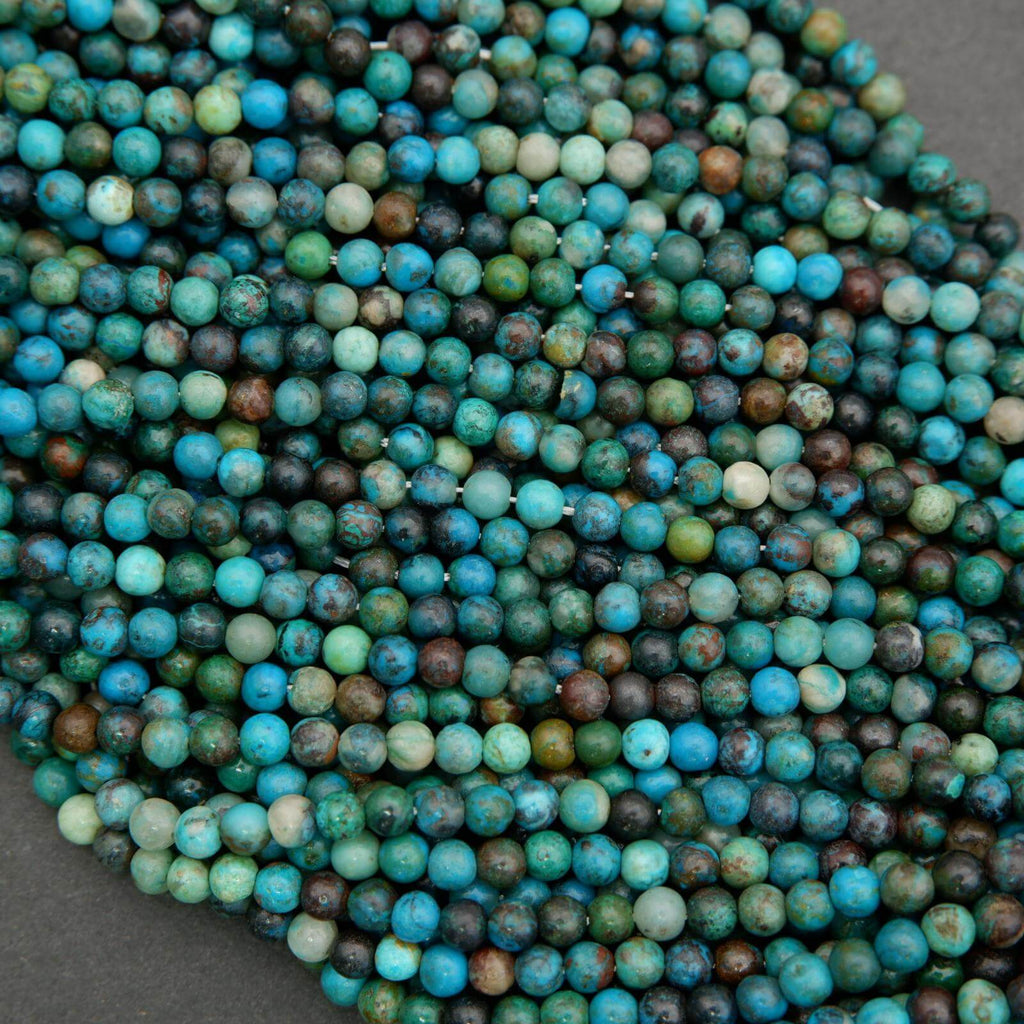 Close-up of blue and green beads on a dark surface