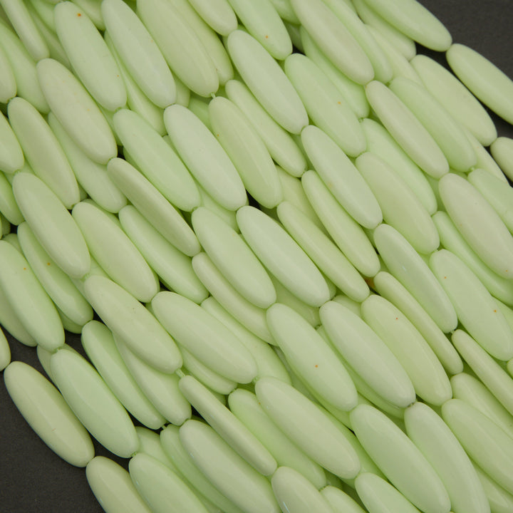 Close-up of light green oval-shaped objects on a dark background