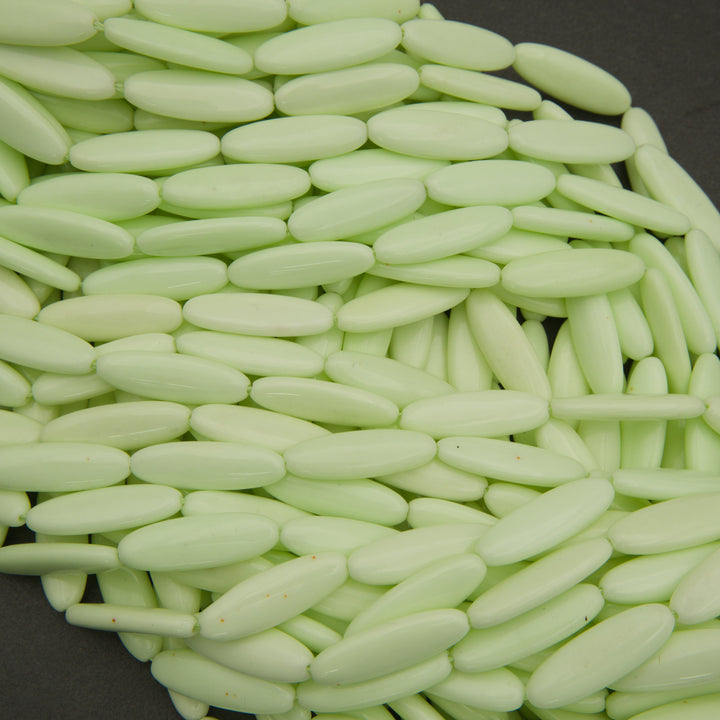 Close-up of light green oval beads on a dark background