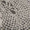 Strands of faceted clear quartz star beads laid in curving rows on a gray background