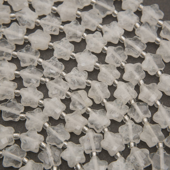 Close-up of faceted clear quartz star beads with natural veils and checkerboard facets