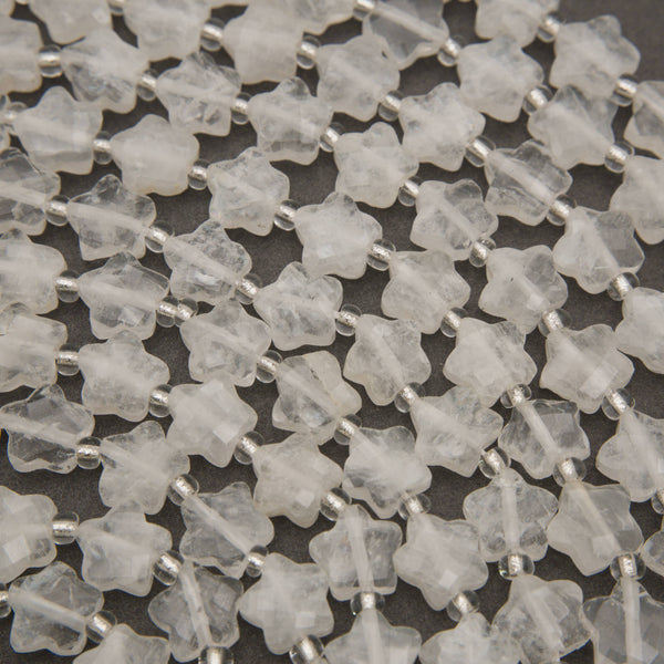 Close-up of faceted clear quartz star beads with natural veils and checkerboard facets
