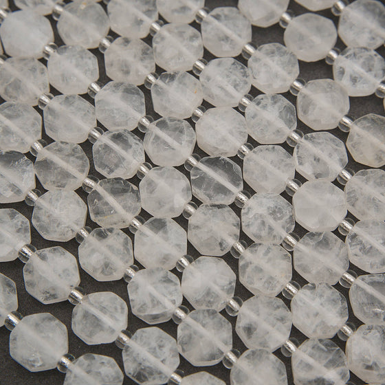 Faceted clear quartz octagon beads with icy white tones, translucent surfaces, and silver spacers.