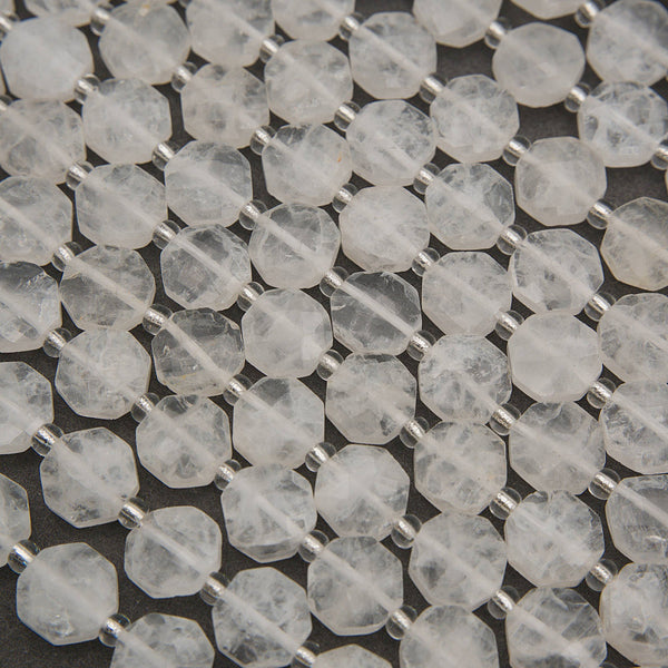 Faceted clear quartz octagon beads with icy white tones, translucent surfaces, and silver spacers.