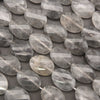 Faceted oval clear quartz gemstone beads arranged in rows on a dark gray background.