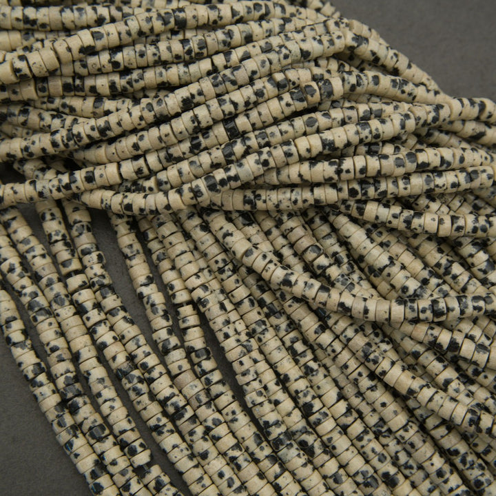Assorted dalmatian jasper bead strands arranged in overlapping rows.
