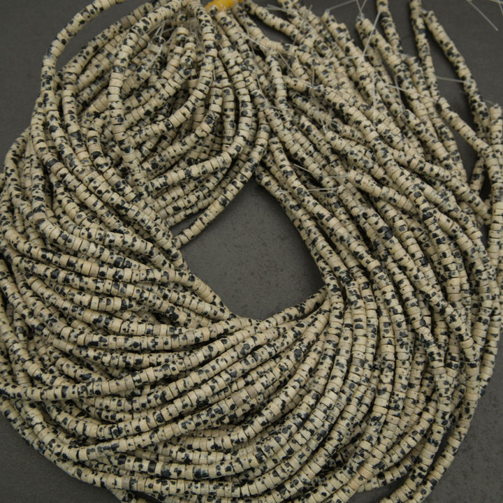 Natural dalmatian jasper heishi beads displaying organic speckling and matte-to-polished finish.