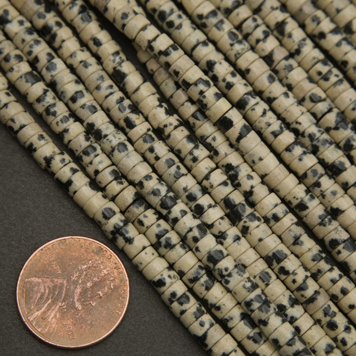Bundle of dalmatian jasper heishi bead strands with cream and black color contrast.