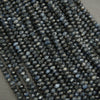 Close-up of dark blue faceted beads on a gray surface