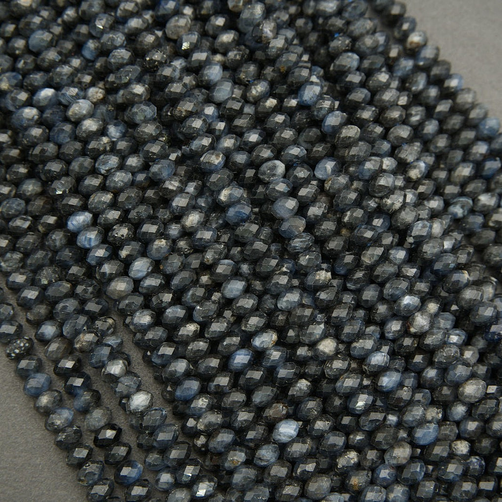 Close-up of dark blue faceted beads on a gray surface