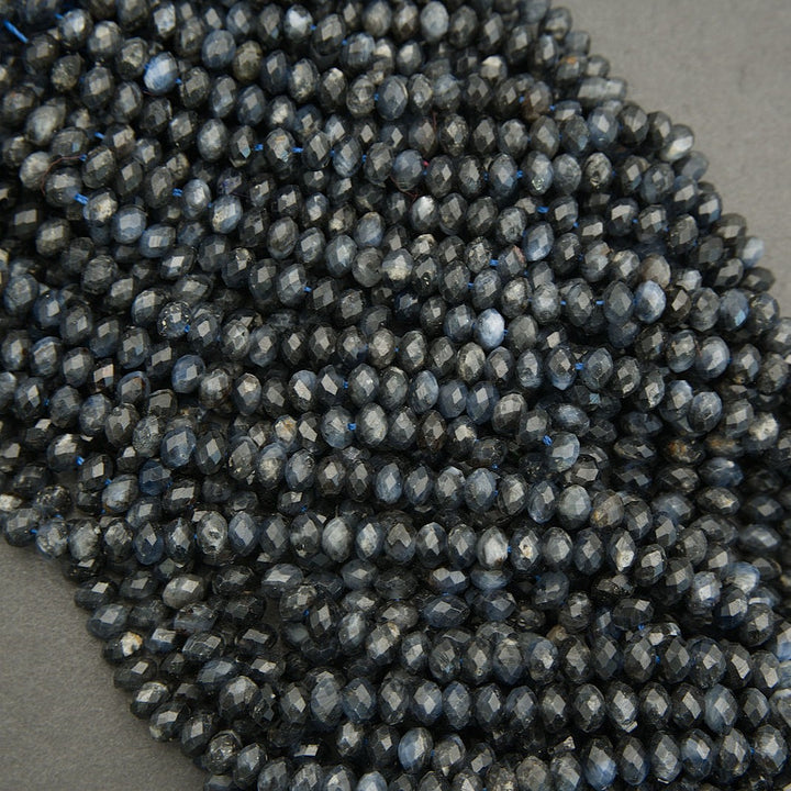 Close-up of dark blue faceted beads on a gray surface