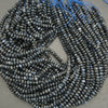 String of dark blue faceted beads on a gray background