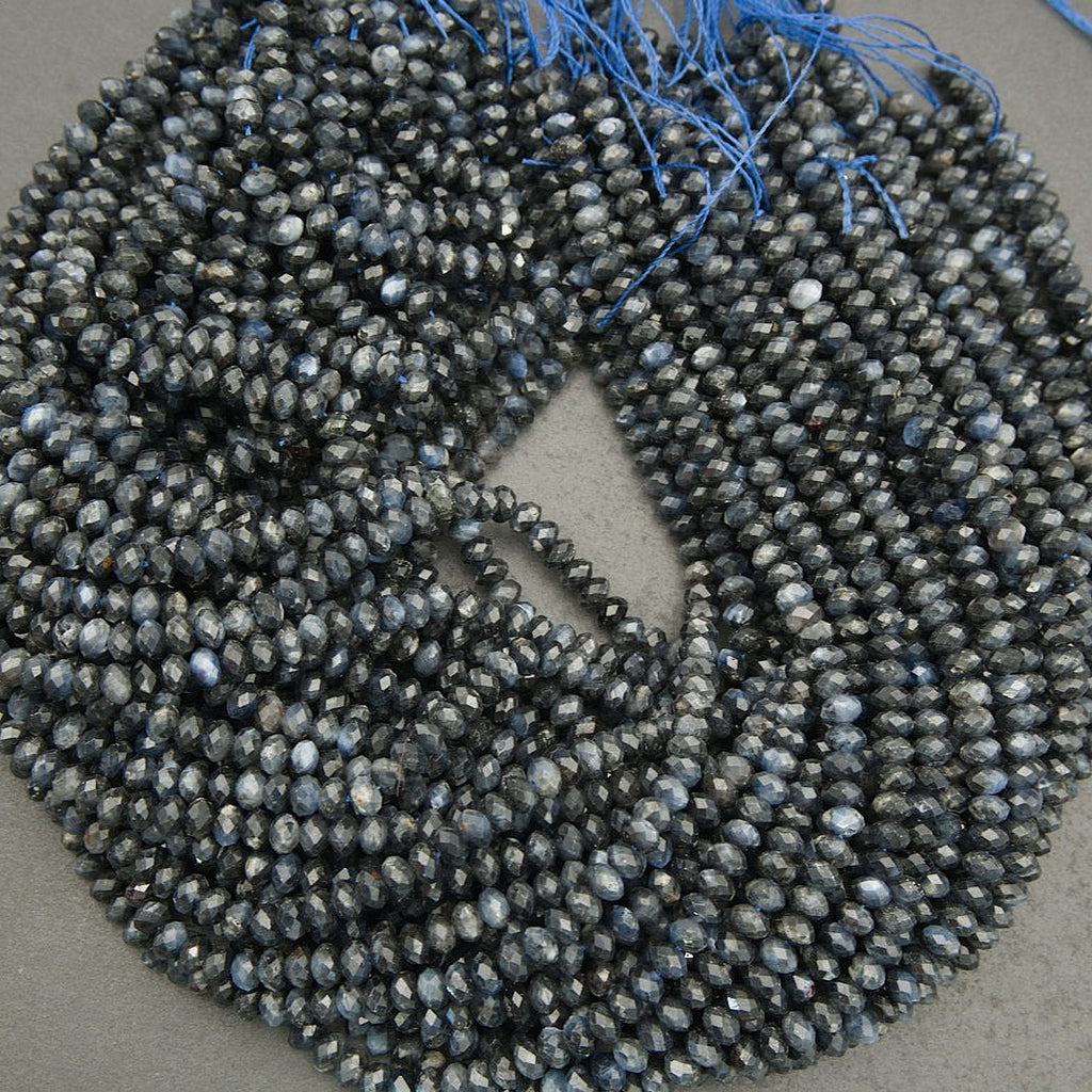 String of dark blue faceted beads on a gray background