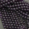 Close-up of dark purple beads on a gray background