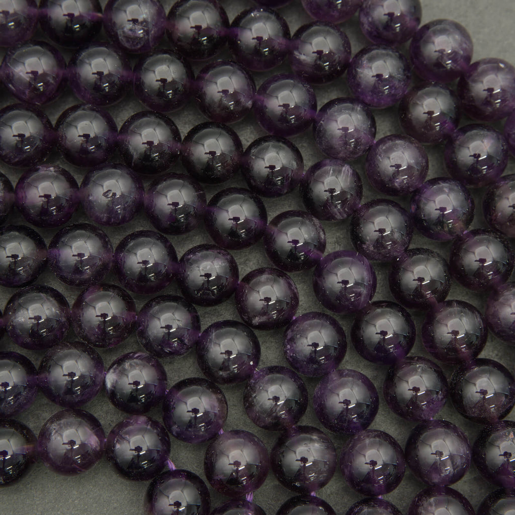 Close-up of purple beads on a string against a neutral background