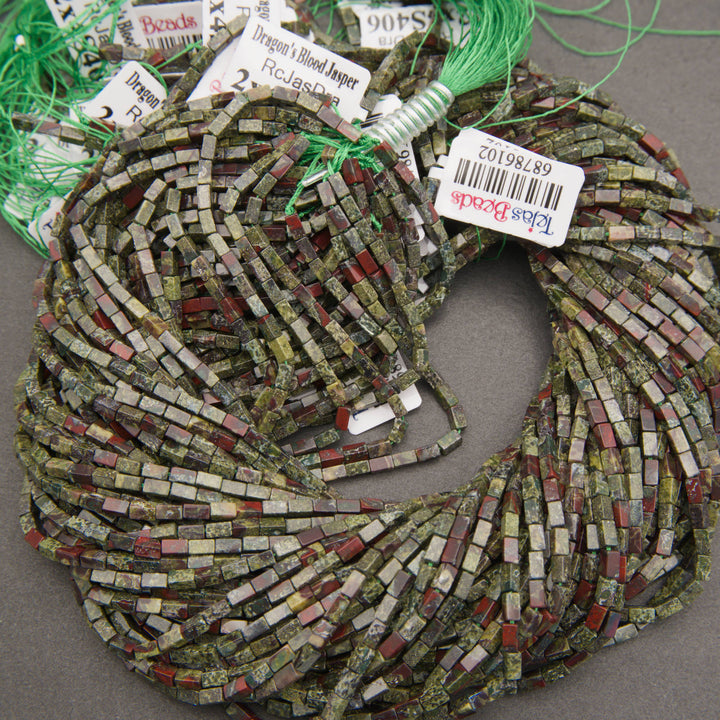Close-up of Dragon Blood Jasper beads displaying contrasting forest green and brick-red mineral patterns.