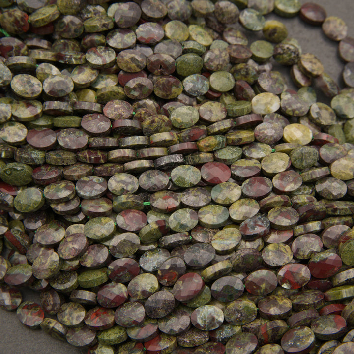 Rows of faceted dragon's blood jasper oval beads on a gray background in olive green, brick red and gray