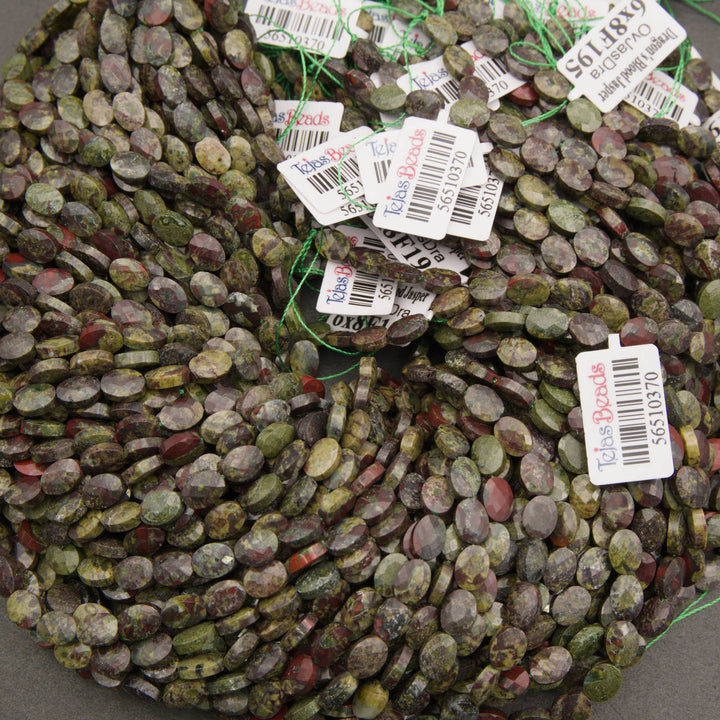 A bundle of faceted dragon's blood jasper oval bead strands with Tejas Beads tags