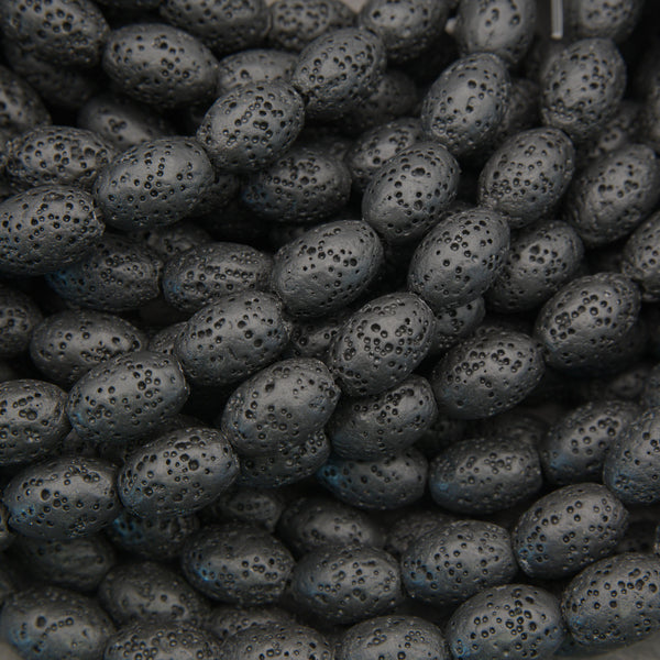 Black lava stone oval beads with a matte finish and naturally porous volcanic texture for jewelry making.