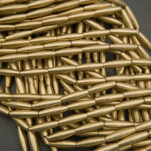 Close-up of gold-colored metal tubes arranged in a woven pattern.