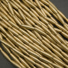 Close-up of gold cylindrical beads on a dark background
